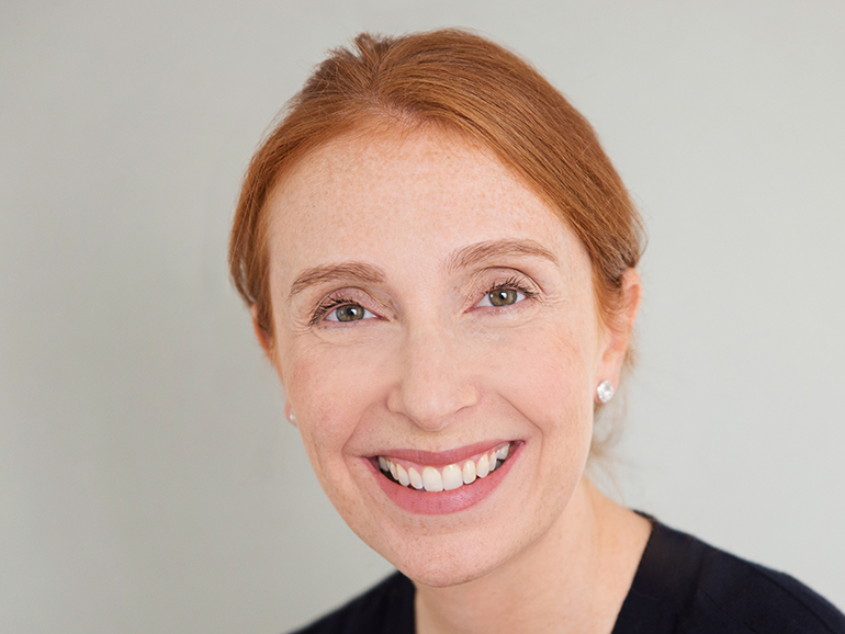 Kathryn Levy smiling at the camera in a black top